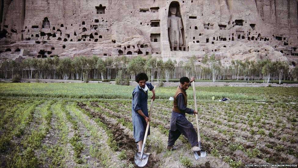 เกษตรกร เตรียมความพร้อมสำหับทุ่งข้าวสาลี ด้านหน้าของพระพุทธรูป ภาพถ่ายในปี 1992 (ที่มา BBC)